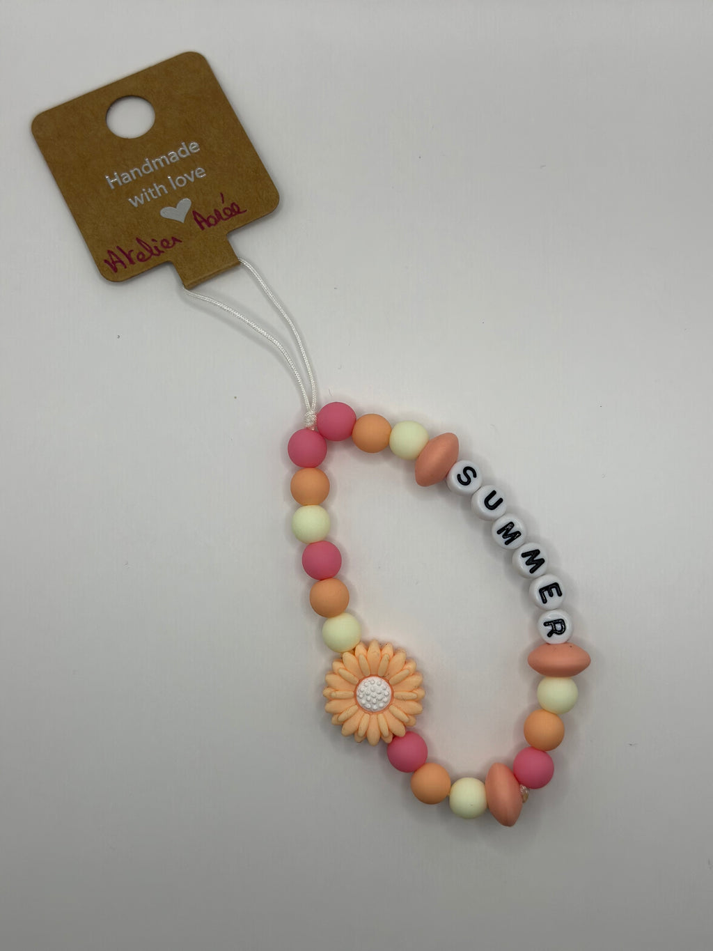 Détail bijou téléphone artisanal couleurs estivales fait main France 