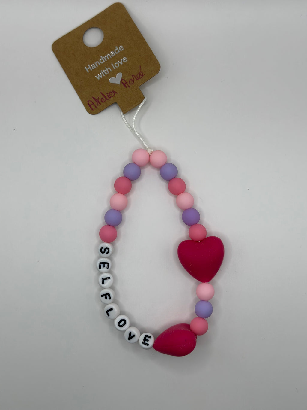Détail bijou téléphone artisanal lettres SELFLOVE cœurs fait main France