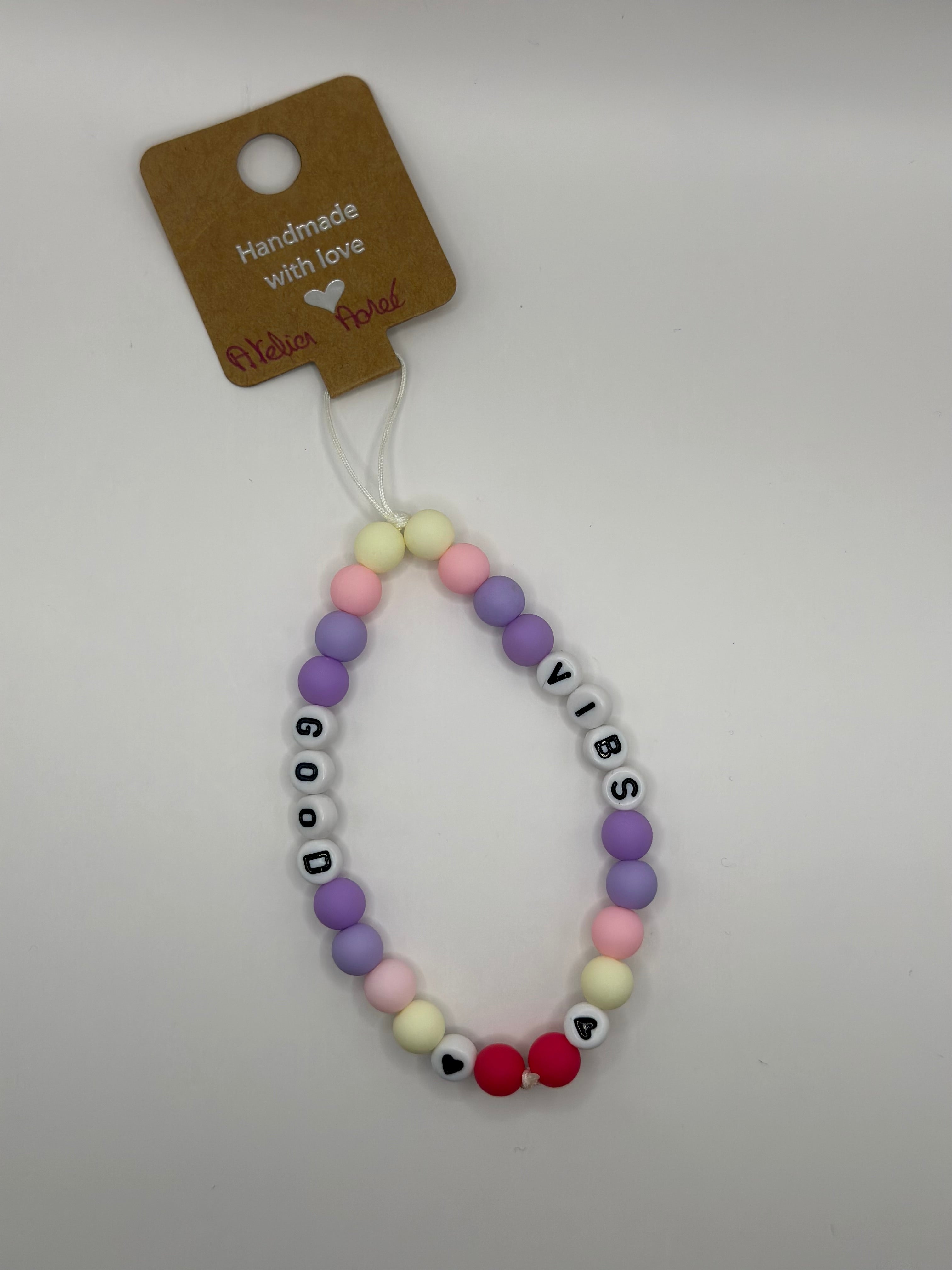 Détail bijou téléphone artisanal lettres GOOD VIBS fait main France