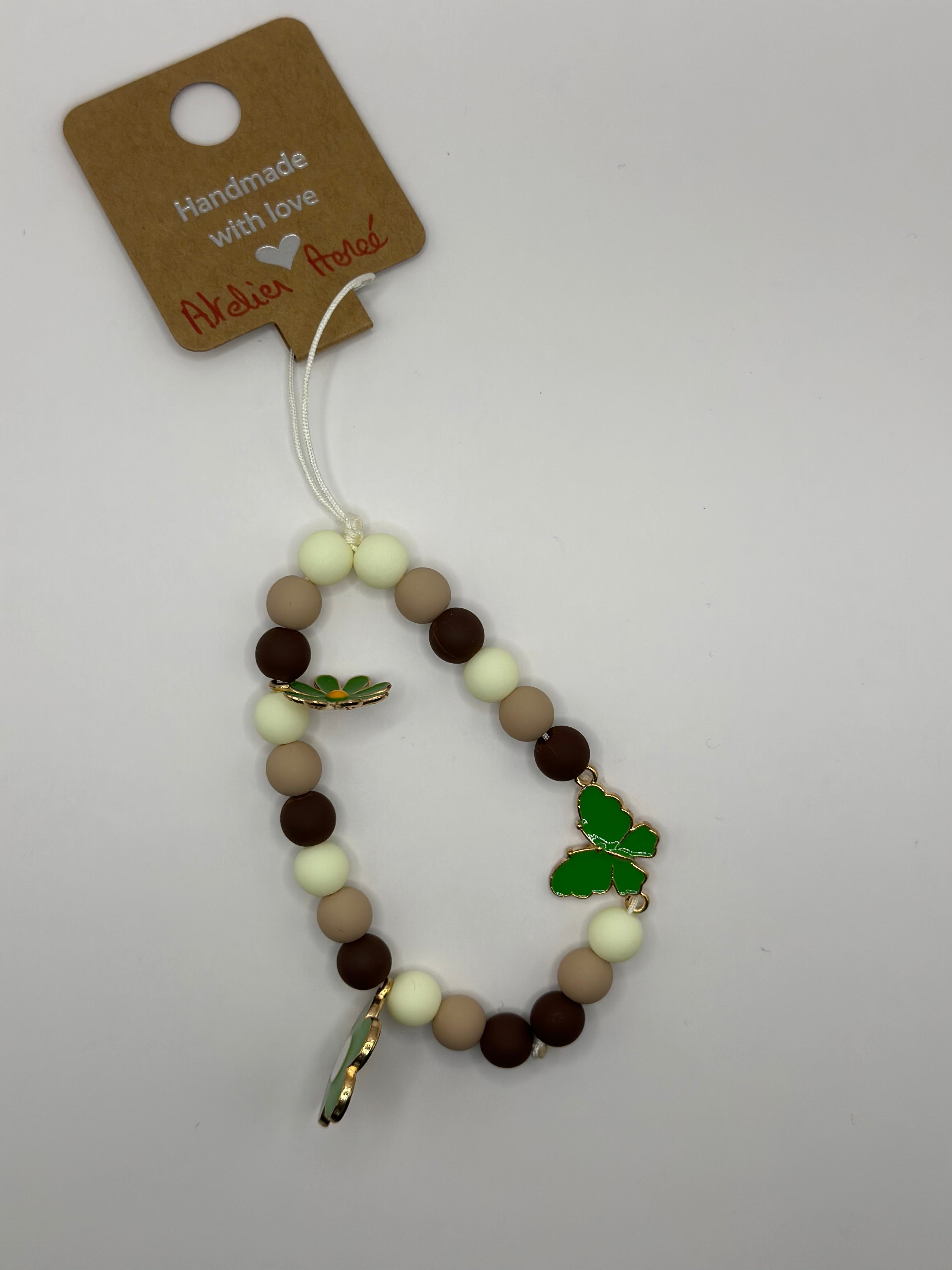 Détail bijou téléphone artisanal papillons délicats fait main France