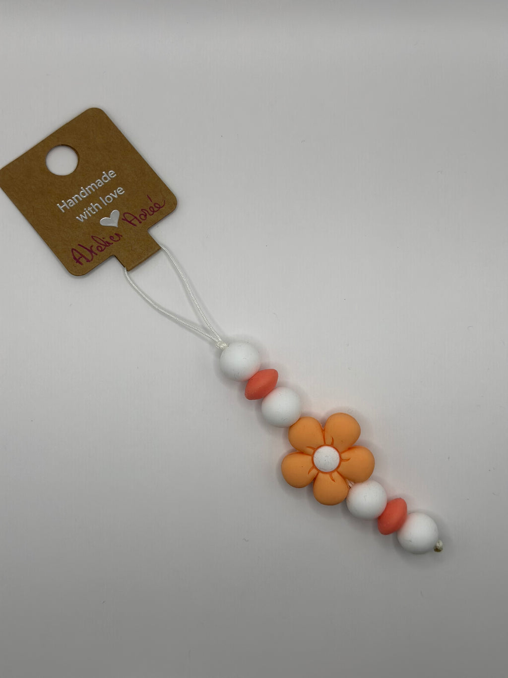 Détail bijou téléphone artisanal couleur pêche croquante fait main France
