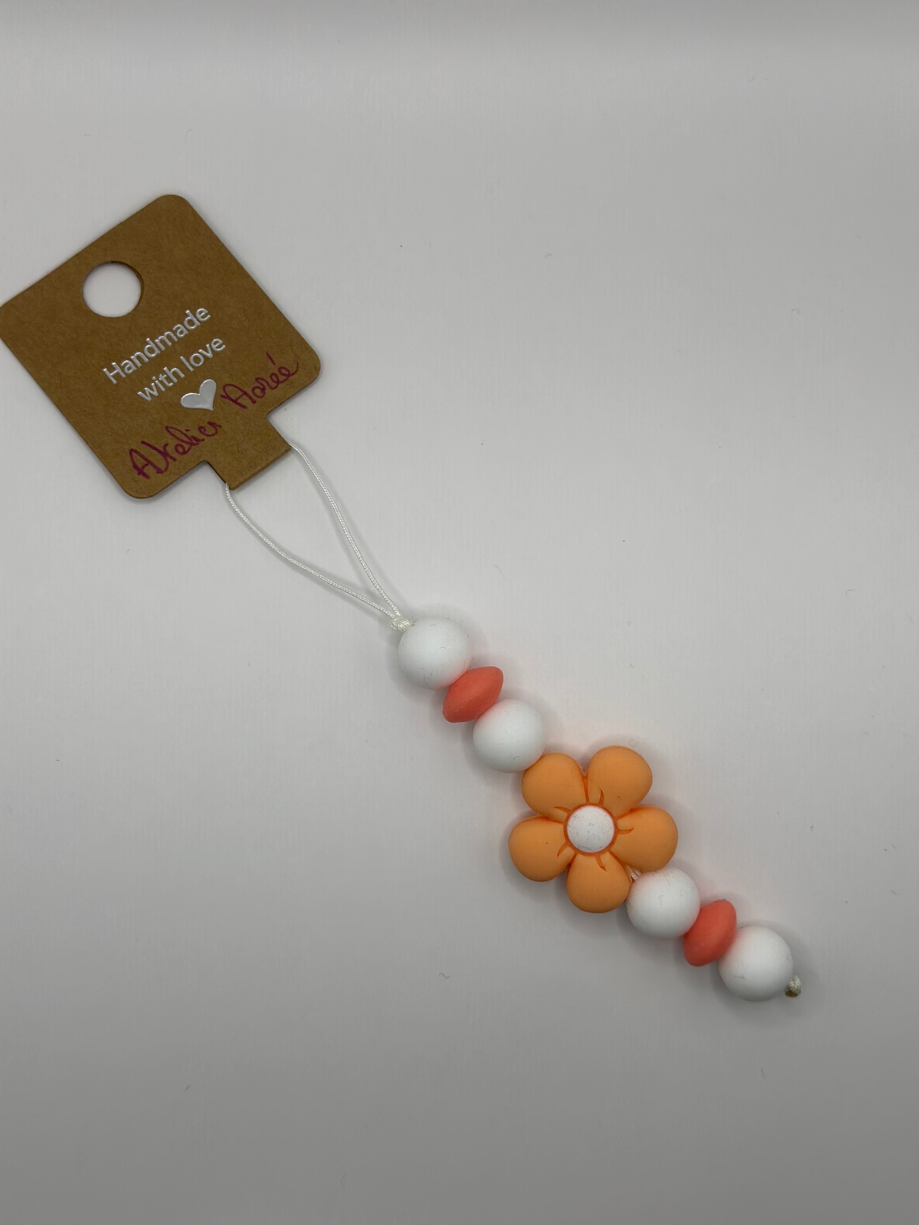 Détail bijou téléphone artisanal couleur pêche croquante fait main France
