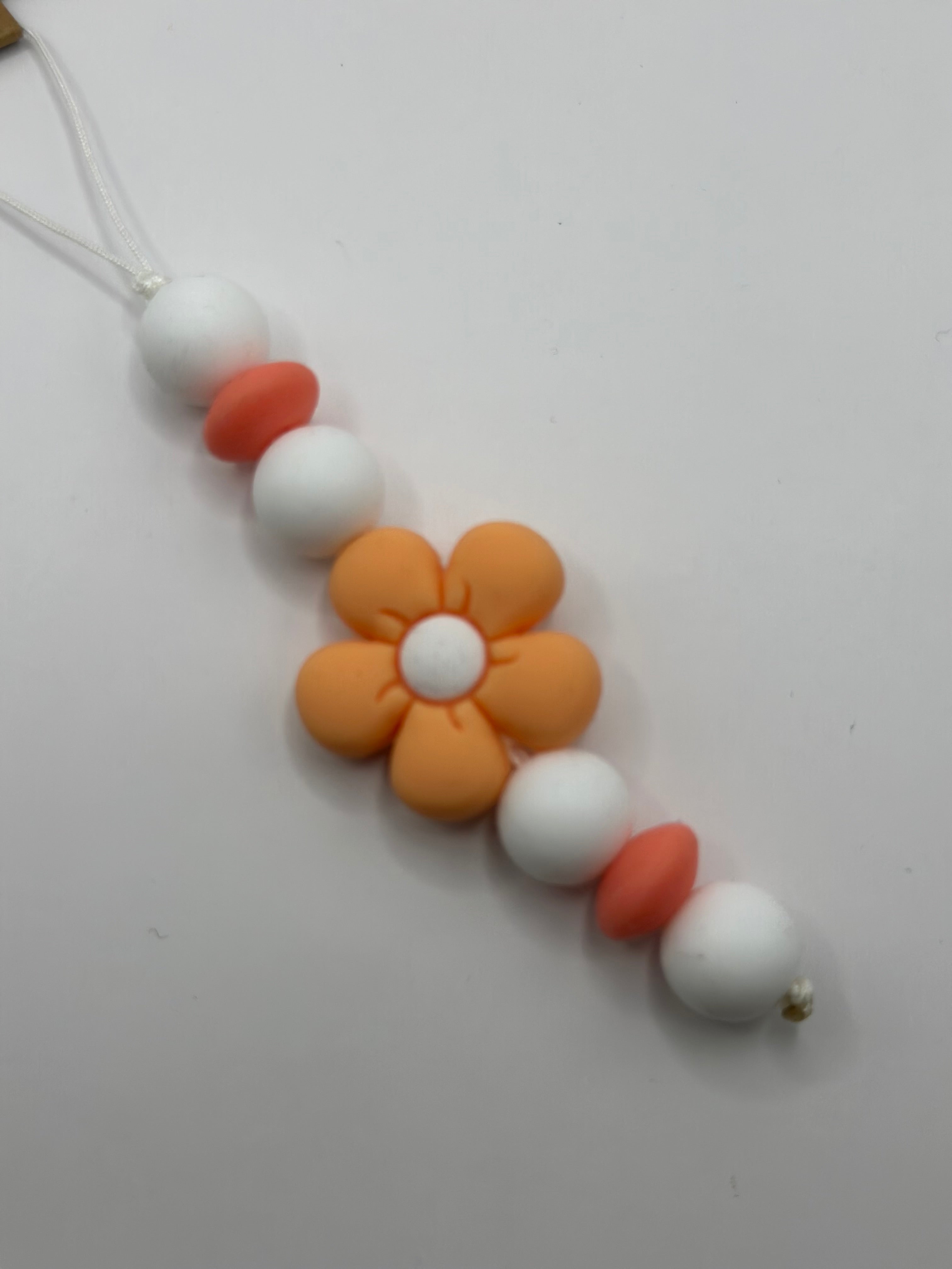 Détail bijou téléphone artisanal couleur pêche croquante fait main France
